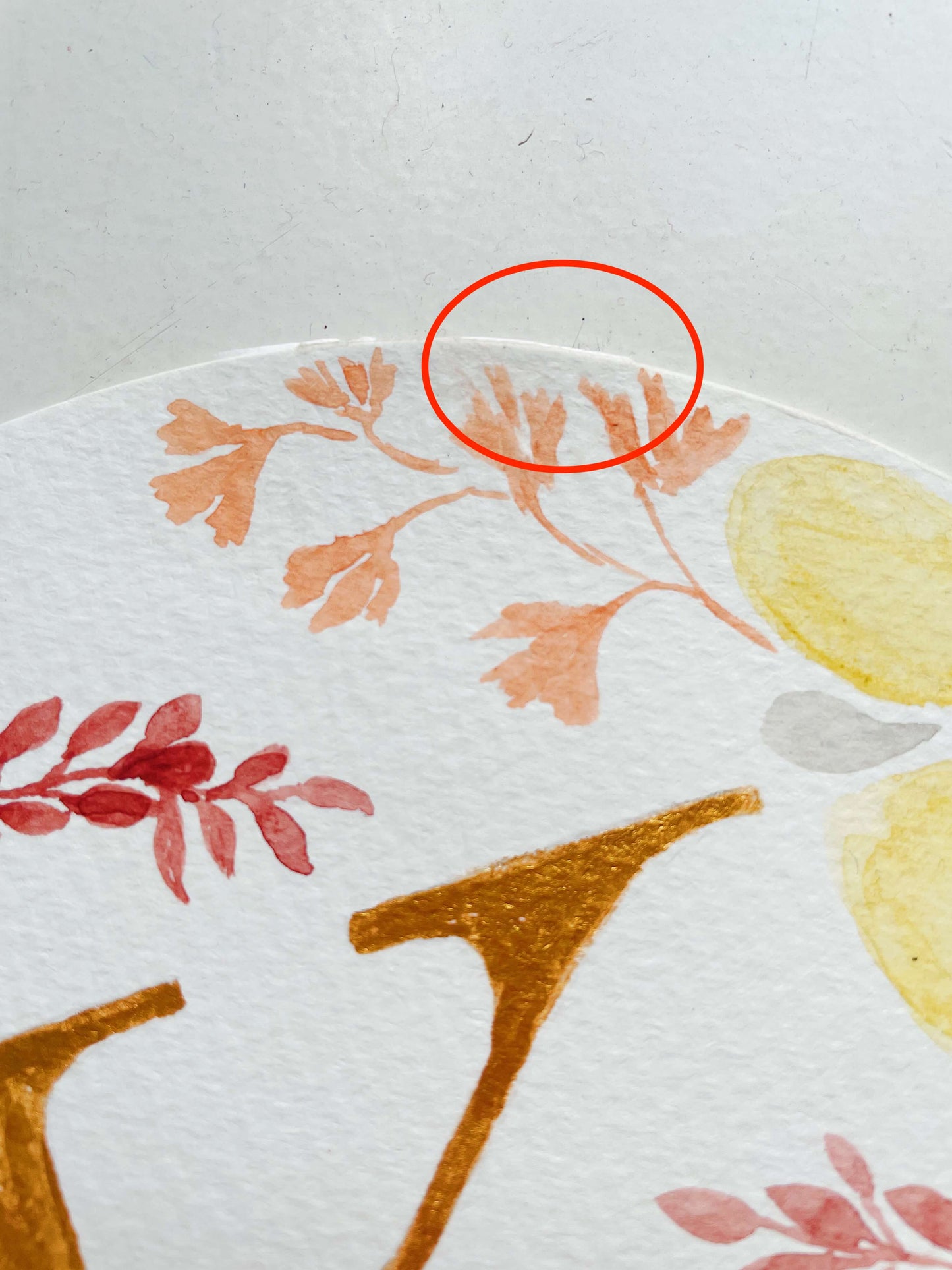 Closeup of very superficial tear on Letter K Monogram that has been repaired with a paper joint.