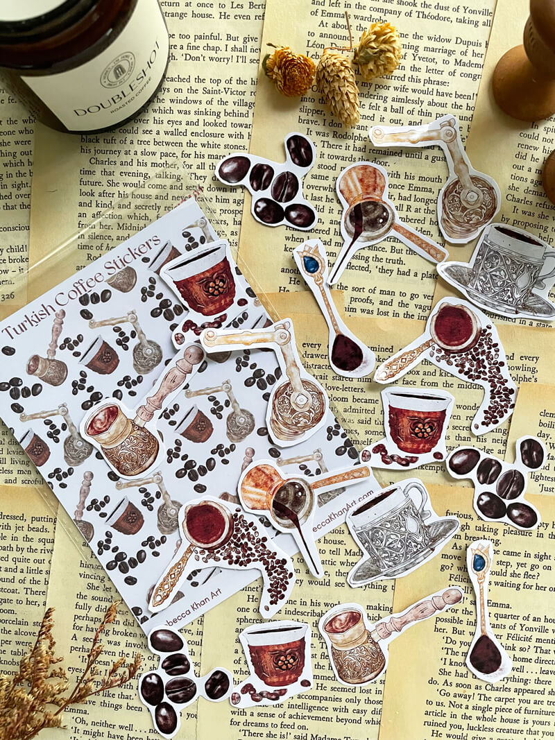A pack labeled Turkish Coffee Stickers with stickers of vintage Turkish coffee cezves and coffee beans and antique style Turkish coffee cups with traditional Eastern metalwork.  The stickers are scattered on a backdrop of book pages.