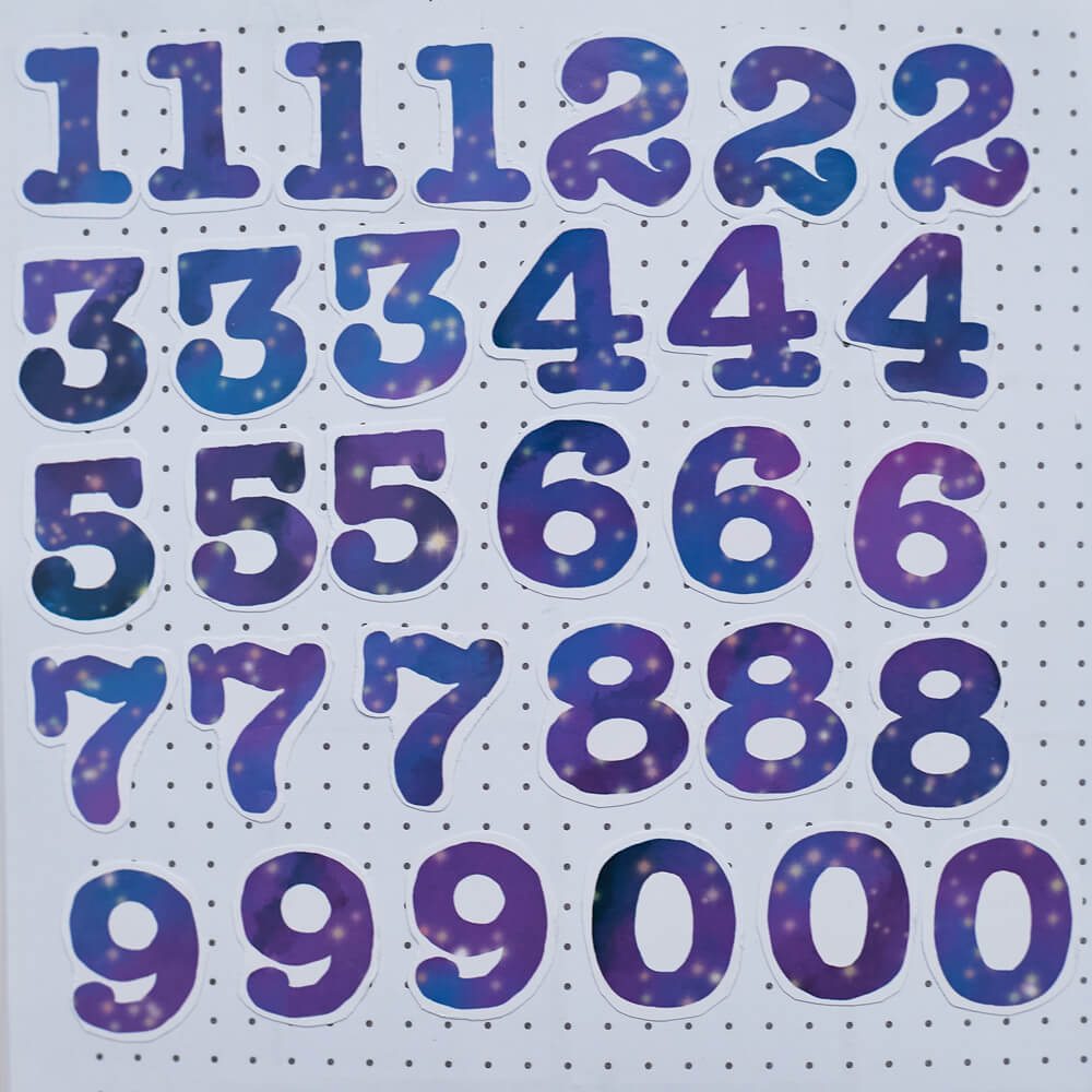 All 31 of the Galactic Dreamer Numbers stickers in a grid. The stickers are starry galaxies in the shape of the numbers 0 through 9.