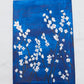 An acrylic painting on canvas depicting white blossoms against a moody blue background.