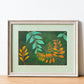 Art print of a gouache painting of gold and teal leaves reaching towards each other against a dark green background in a painted white frame with pale green matting.