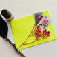 Two vintage stamp stickers on an envelope with some dried flowers, a quill and an ink bottle.
